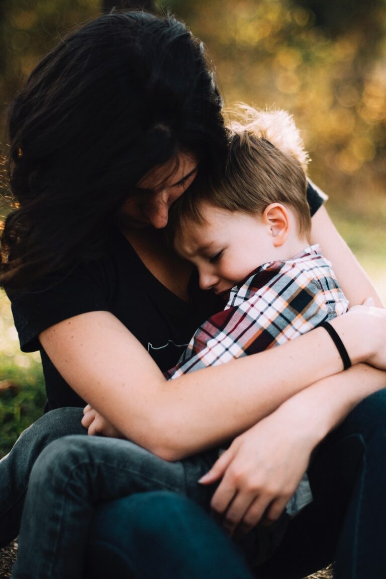 woman hugging boy on her lap
